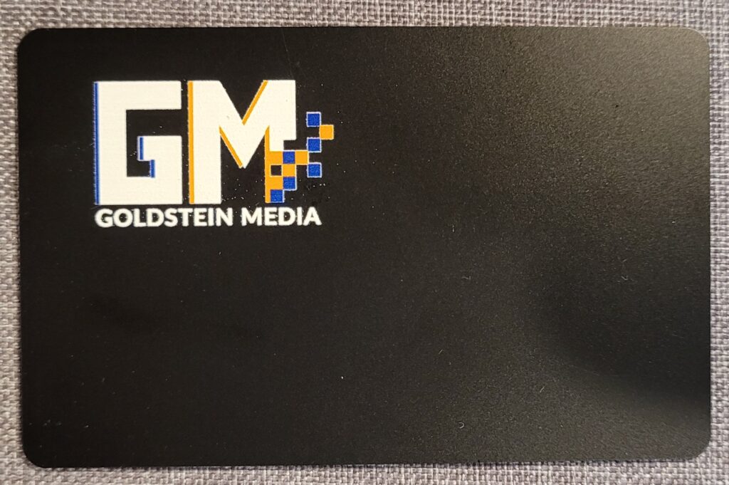 linq-card - Black plastic NFC ard on gray weave background.