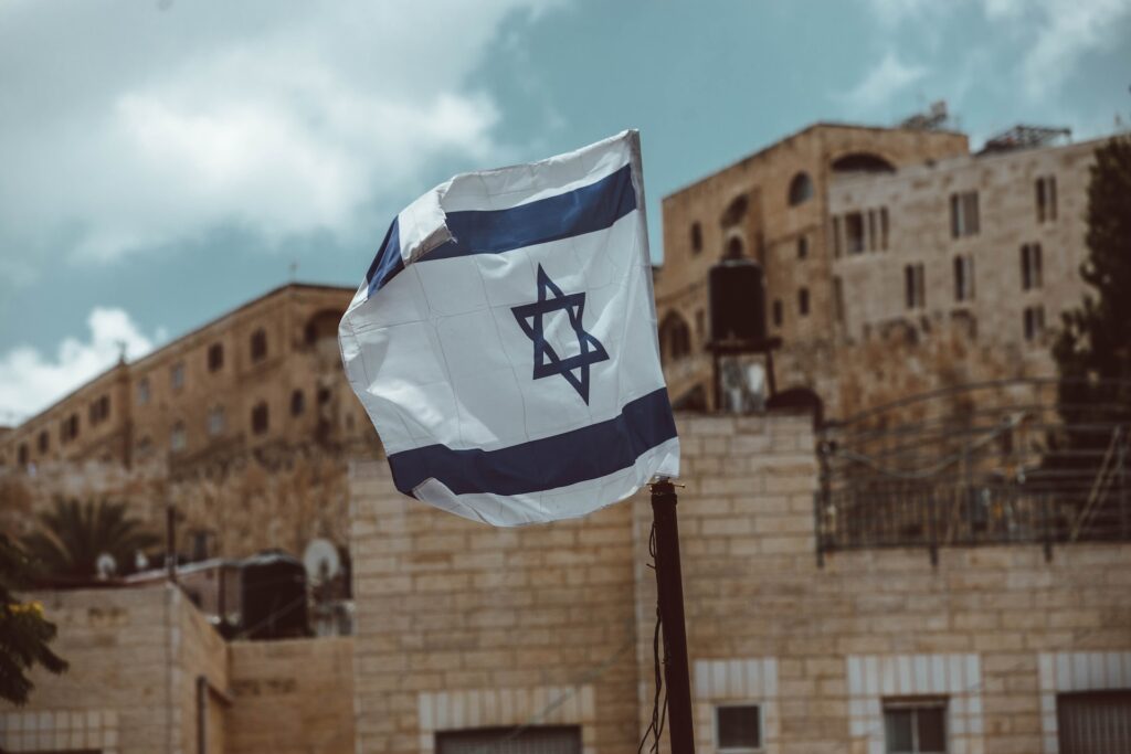 israeli-flag-flying-in-israel-unsplash-Taylor-Brandon