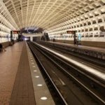 A spacious underground train station with an arched ceiling and empty tracks.