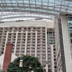 Interior view of a large atrium with multiple floors and a glass ceiling.